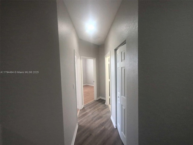 hall featuring baseboards and dark wood-style floors
