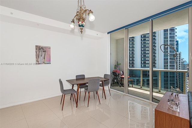tiled dining area featuring baseboards, floor to ceiling windows, and a notable chandelier