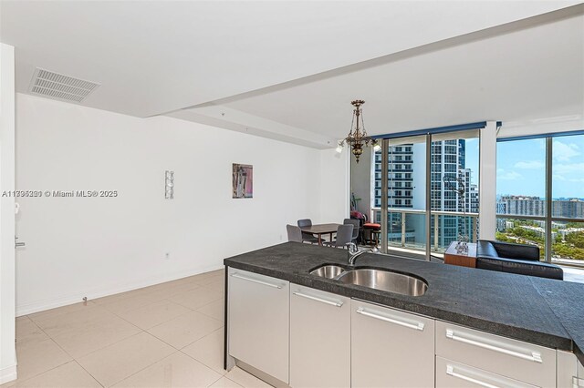 18201 Collins Ave Unit 3405, Sunny Isles Beach, FL 33160 - kitchen with visible vents, a view of city, an inviting chandelier, white cabinets, and a sink