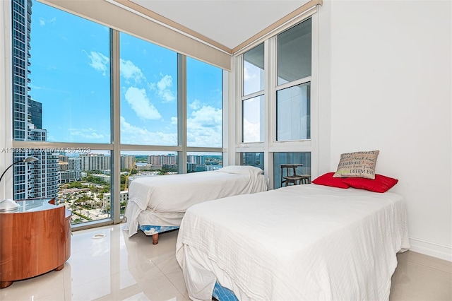 bedroom with tile patterned floors, baseboards, and a city view