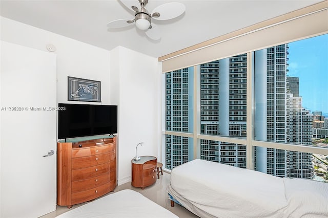 bedroom featuring a view of city and ceiling fan