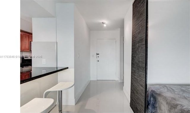 hallway with baseboards and light tile patterned flooring