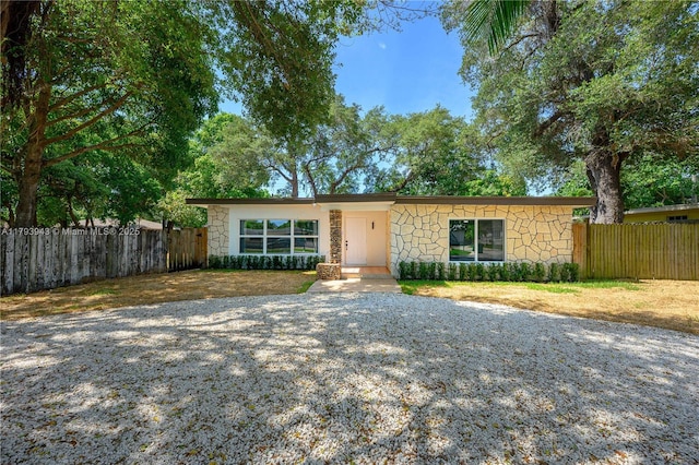 736 NE 164th St, Miami, FL 33162 - mid-century modern home featuring stone siding and gravel driveway