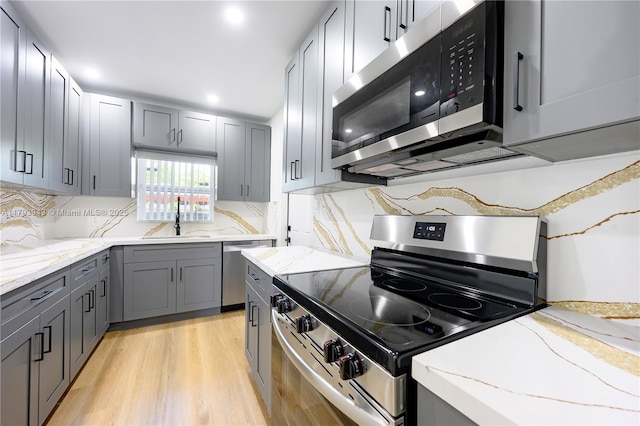 736 NE 164th St, Miami, FL 33162 - kitchen featuring appliances with stainless steel finishes, gray cabinets, a sink, light stone countertops, and recessed lighting