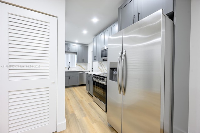 736 NE 164th St, Miami, FL 33162 - kitchen featuring stainless steel appliances, light countertops, gray cabinets, light wood-style flooring, and recessed lighting