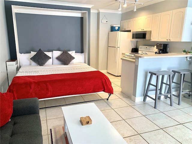 bedroom featuring light tile patterned floors, ornamental molding, and freestanding refrigerator