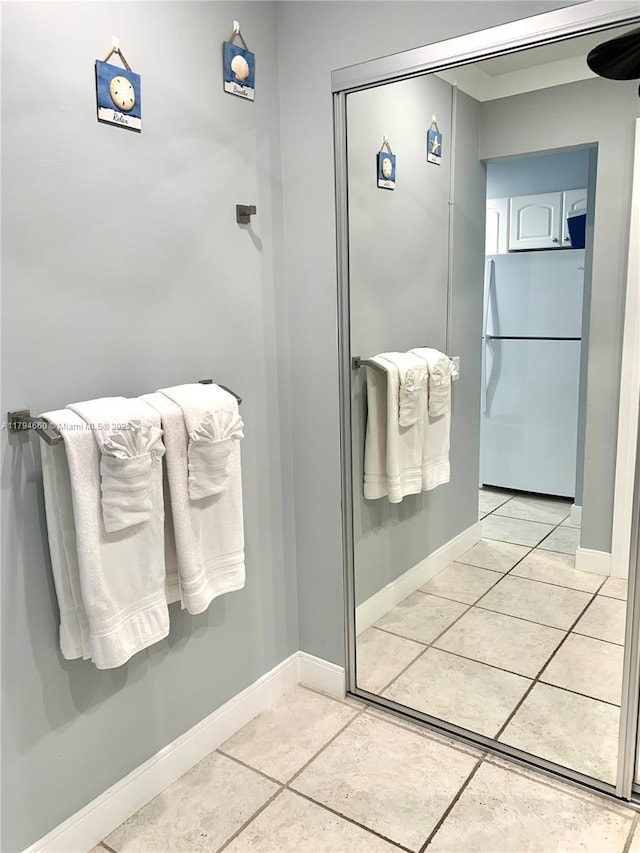 bathroom with baseboards and tile patterned floors
