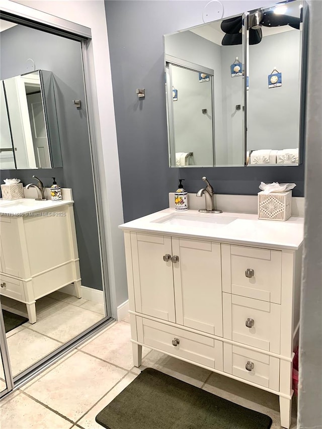 bathroom with a sink, tile patterned flooring, and two vanities