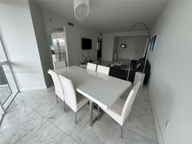 dining area featuring an inviting chandelier, baseboards, and visible vents