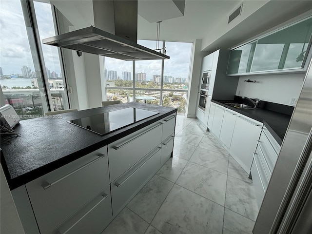 kitchen with wall chimney range hood, a view of city, dark countertops, and stainless steel appliances