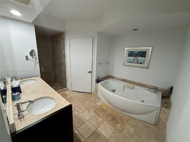 full bathroom with a jetted tub, a sink, a stall shower, and visible vents