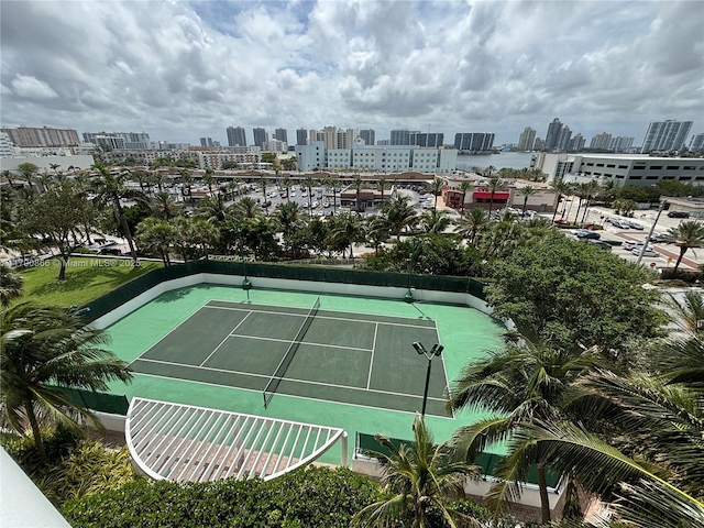 view of sport court with fence and a city view