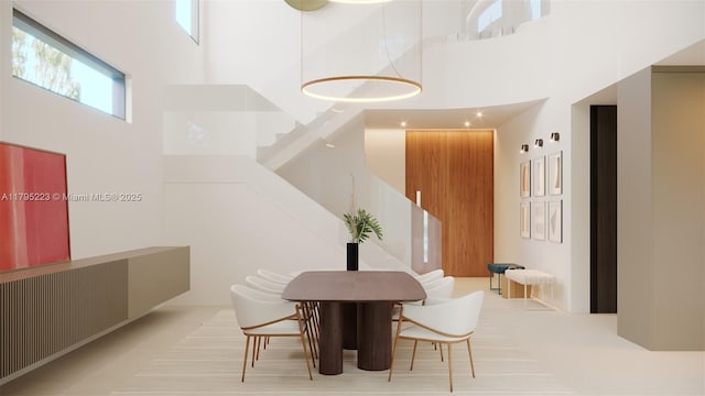 dining area with stairs and a towering ceiling