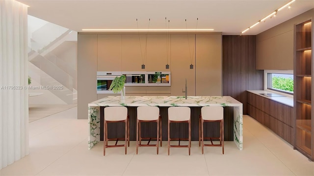 kitchen featuring a breakfast bar area, modern cabinets, a sink, light stone counters, and oven
