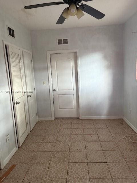 unfurnished room with light tile patterned floors, baseboards, ceiling fan, and visible vents