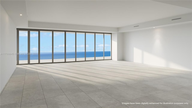 empty room featuring a water view and recessed lighting