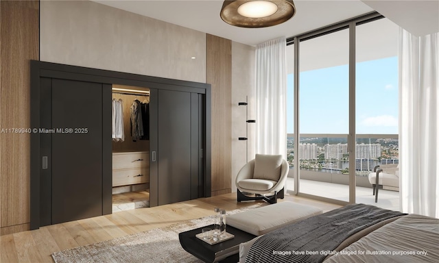 bedroom featuring access to outside, floor to ceiling windows, and wood finished floors