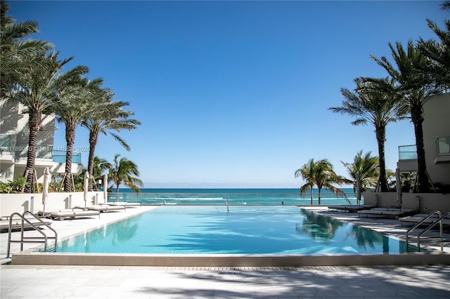 pool with a water view and a patio area
