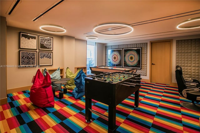 rec room with baseboards and carpet flooring