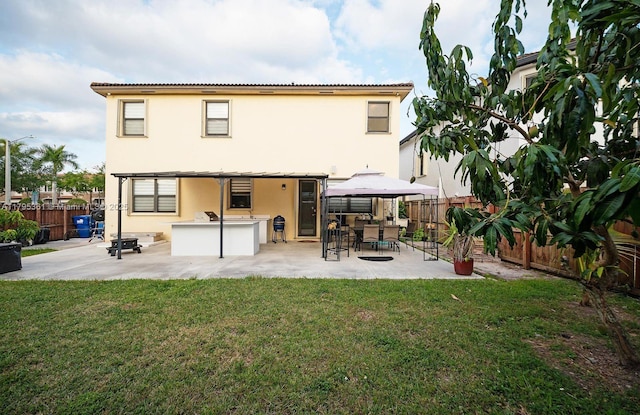 back of house featuring a yard, a patio, a bar, and a fenced backyard