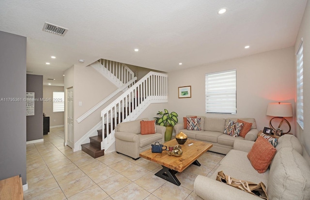 living room featuring recessed lighting, baseboards, visible vents, light tile patterned flooring, and stairway