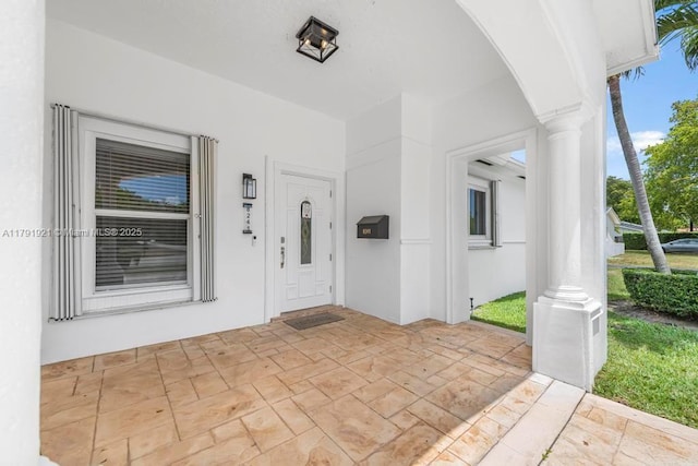 property entrance featuring stucco siding and covered porch
