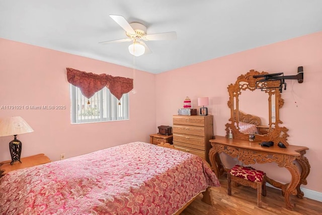 bedroom with baseboards, a ceiling fan, and wood finished floors