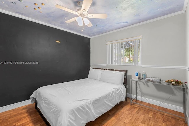 bedroom featuring baseboards, ceiling fan, and wood finished floors