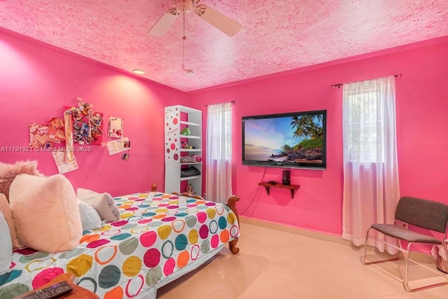 bedroom featuring baseboards, a textured ceiling, ceiling fan, and tile patterned floors