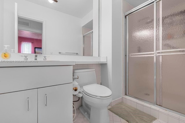 bathroom with vanity, toilet, tile patterned floors, and a stall shower
