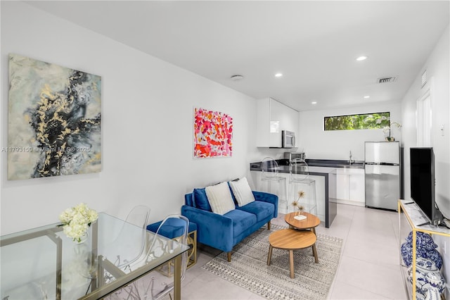 living area with visible vents, light tile patterned flooring, and recessed lighting