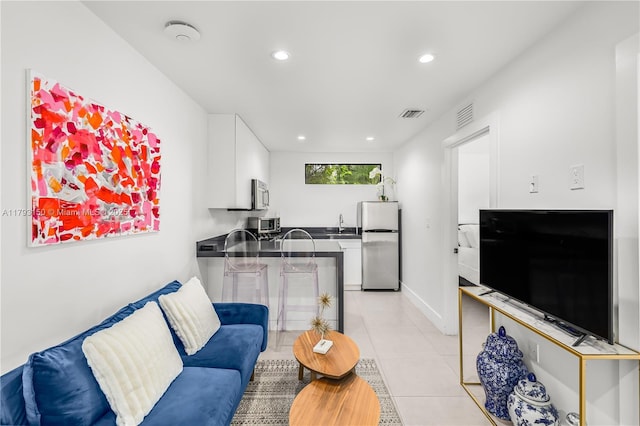 living room featuring baseboards, recessed lighting, visible vents, and light tile patterned flooring