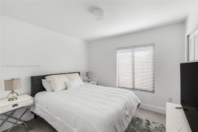 bedroom featuring tile patterned flooring and baseboards