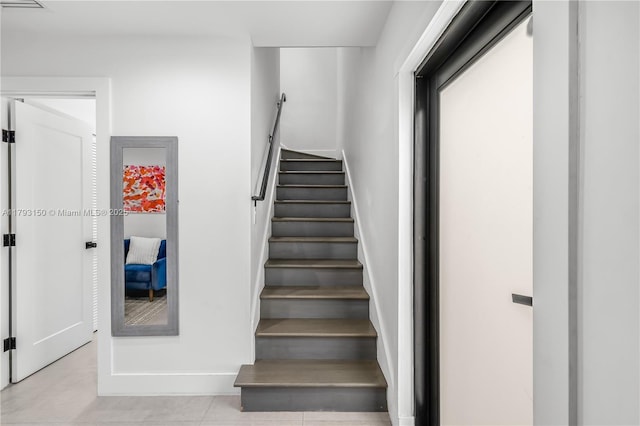 staircase with tile patterned floors and baseboards