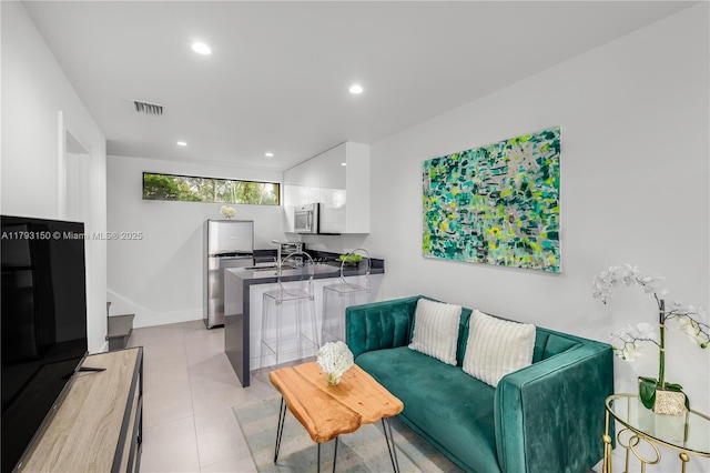 living room with visible vents, light tile patterned flooring, and recessed lighting