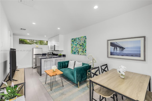 living room featuring light tile patterned flooring, visible vents, and recessed lighting