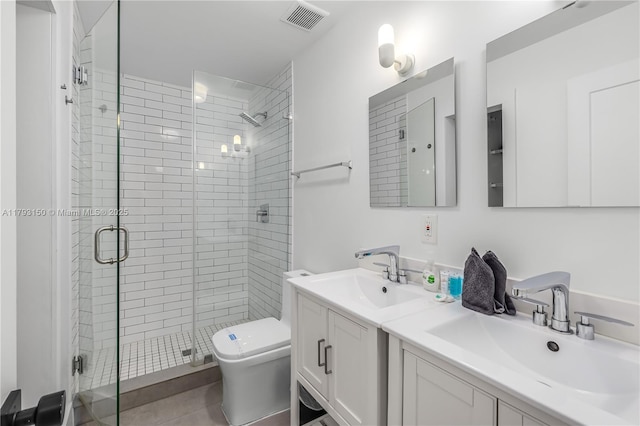 bathroom featuring a sink, toilet, a shower stall, and visible vents