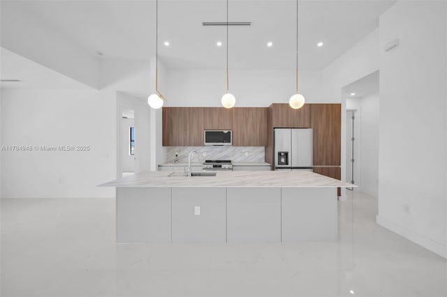 1427 NW 17th St, Cape Coral, FL 33993 - kitchen featuring brown cabinets, light countertops, stainless steel microwave, fridge with ice dispenser, and a towering ceiling