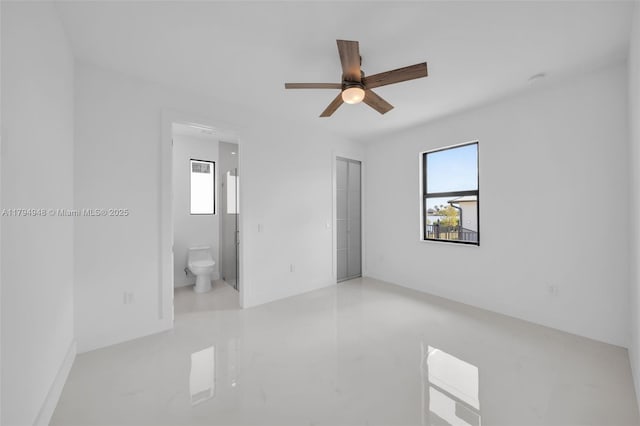1427 NW 17th St, Cape Coral, FL 33993 - unfurnished bedroom featuring marble finish floor, connected bathroom, and ceiling fan
