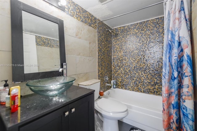 bathroom featuring vanity, shower / bathtub combination with curtain, toilet, and tile walls
