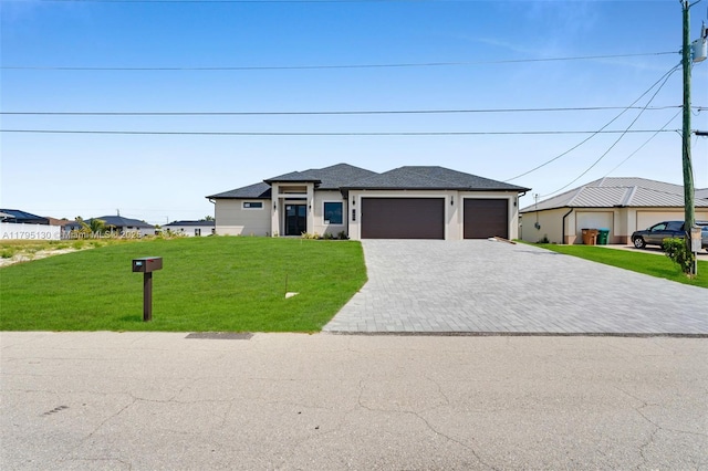 prairie-style home with a garage, a shingled roof, decorative driveway, and a front yard