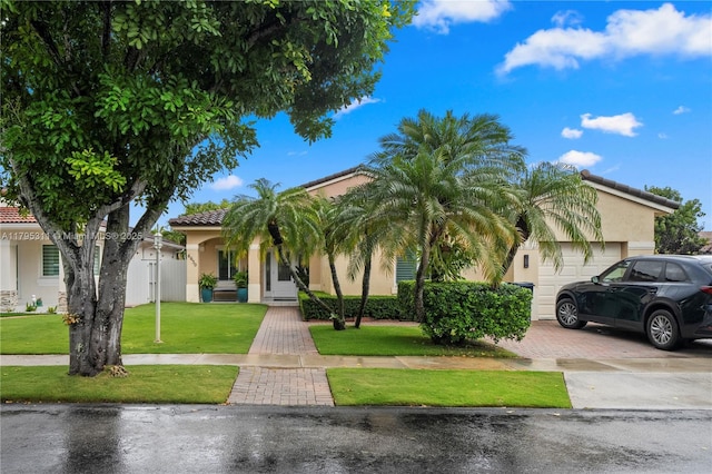 view of front facade with a garage, stucco siding, a tile roof, a front lawn, and decorative driveway