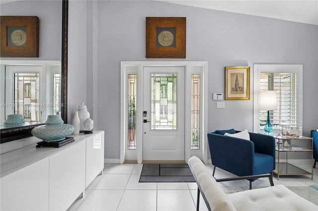 foyer featuring light tile patterned flooring, a high ceiling, and baseboards