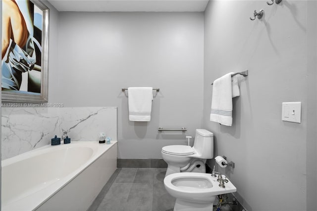 full bath with tile patterned floors, toilet, a garden tub, and a bidet