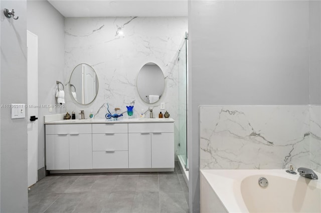 bathroom with double vanity, a stall shower, a garden tub, and a sink