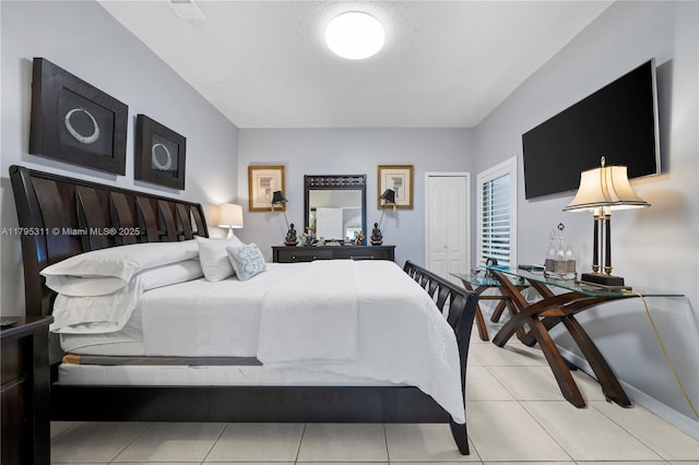bedroom with a closet, baseboards, visible vents, and tile patterned floors
