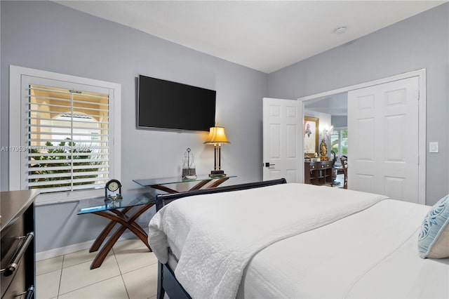 bedroom with light tile patterned floors and baseboards