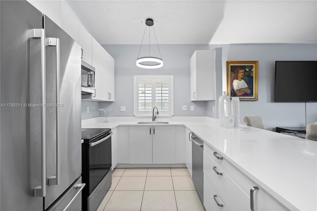 kitchen featuring white cabinetry, light countertops, appliances with stainless steel finishes, and a sink