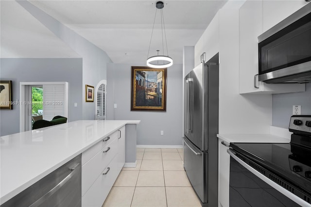 kitchen featuring light tile patterned floors, hanging light fixtures, white cabinetry, light countertops, and appliances with stainless steel finishes