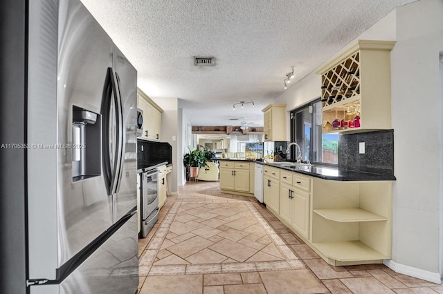 kitchen with visible vents, appliances with stainless steel finishes, cream cabinets, open shelves, and a peninsula